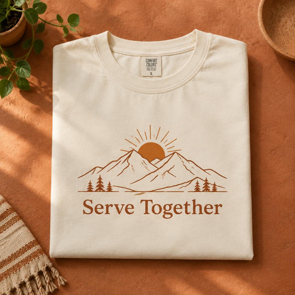 Serve Together t-shirt, front view, folded on a terracotta surface
